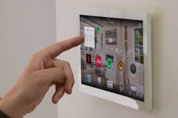 Person using a wall-mounted Control4 touch panel