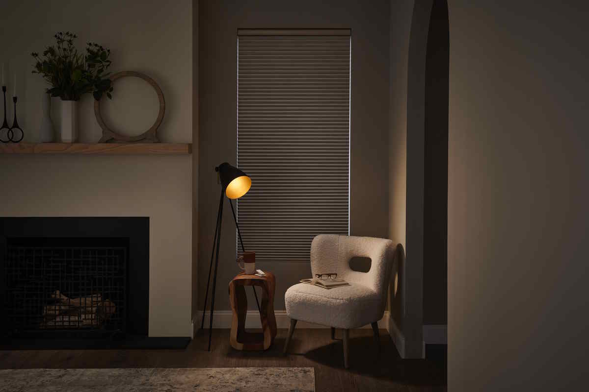 Cozy reading nook with an armchair, open book, side table, and warm lamp lighting.