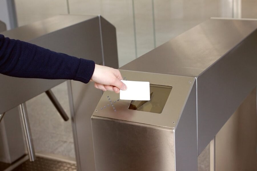 An employee using a keycard to scan into their company building via an access control system.