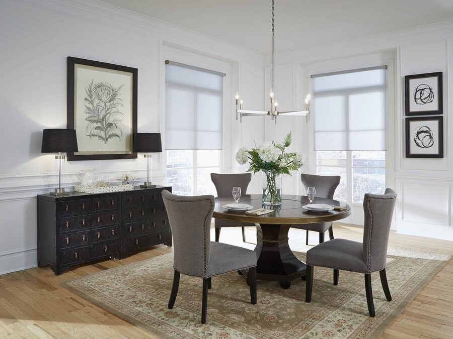 A dining area featuring a Lutron lighting fixture and motorized shades.