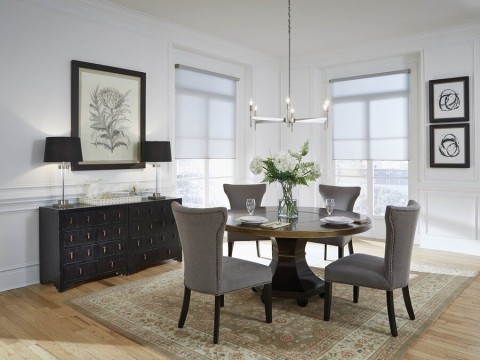 A dining area featuring a Lutron lighting fixture and motorized shades.