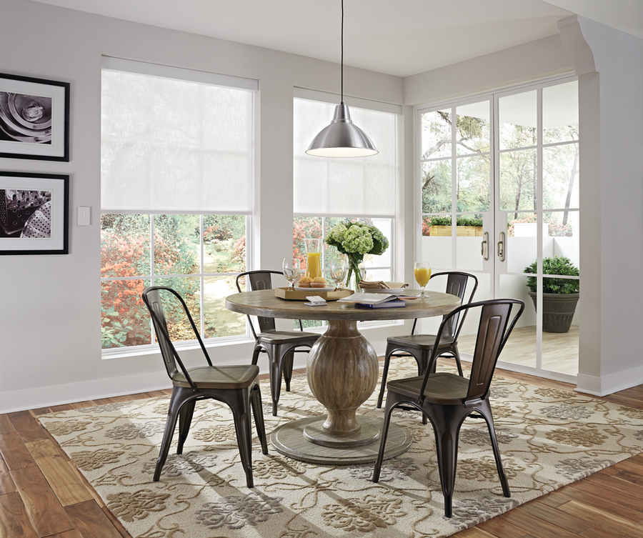 A dining room space featuring smart shades over the windows.