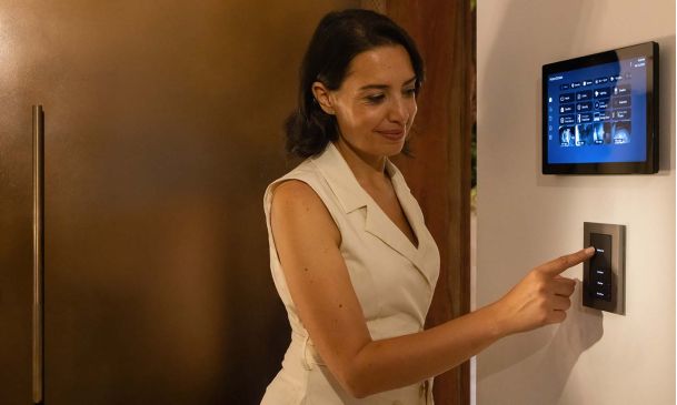 person using a control4 touch panel on the wall