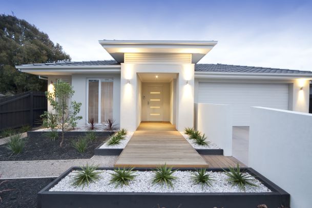 white modern home with lighting at dusk