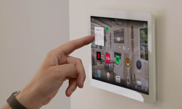 person using a control4 touch panel on the wall