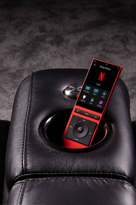 red control4 neeo remote in a leather couch